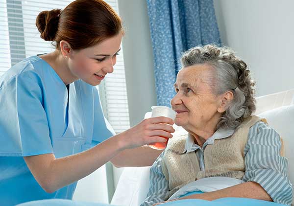Senior woman being fed by a nurse